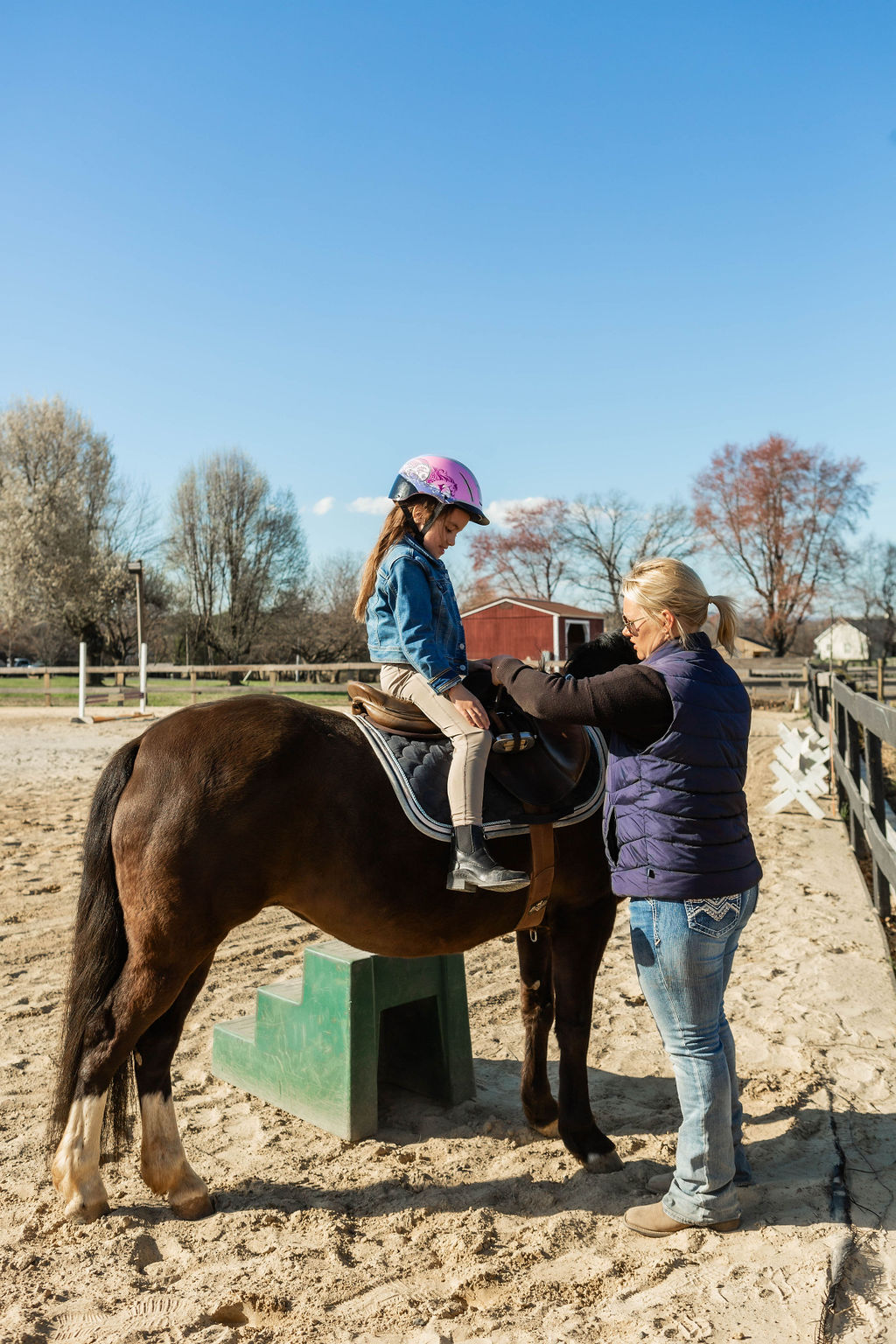 Olivia helping a young rider get settled on her horse