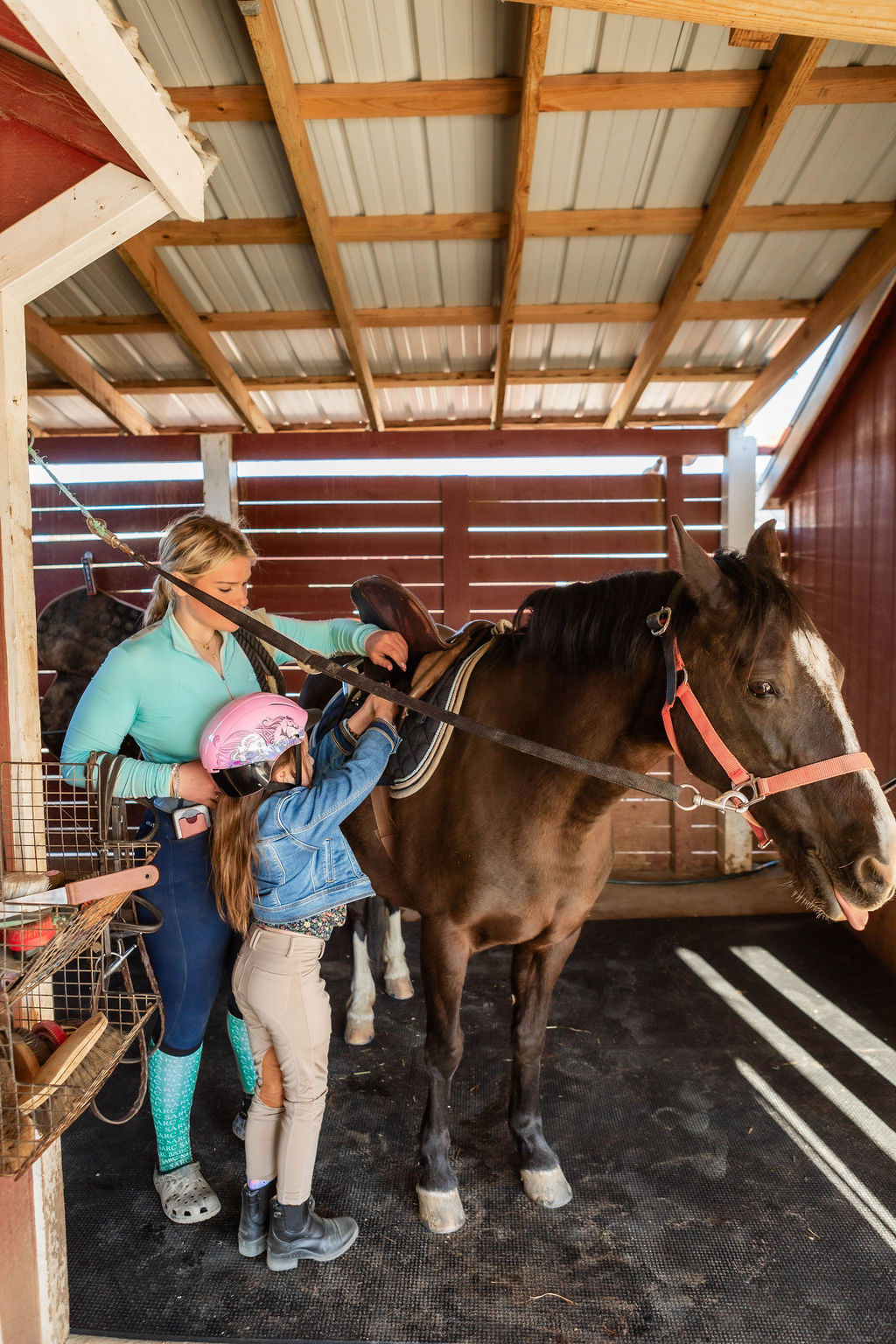 Rider tacking up their horse in the barn