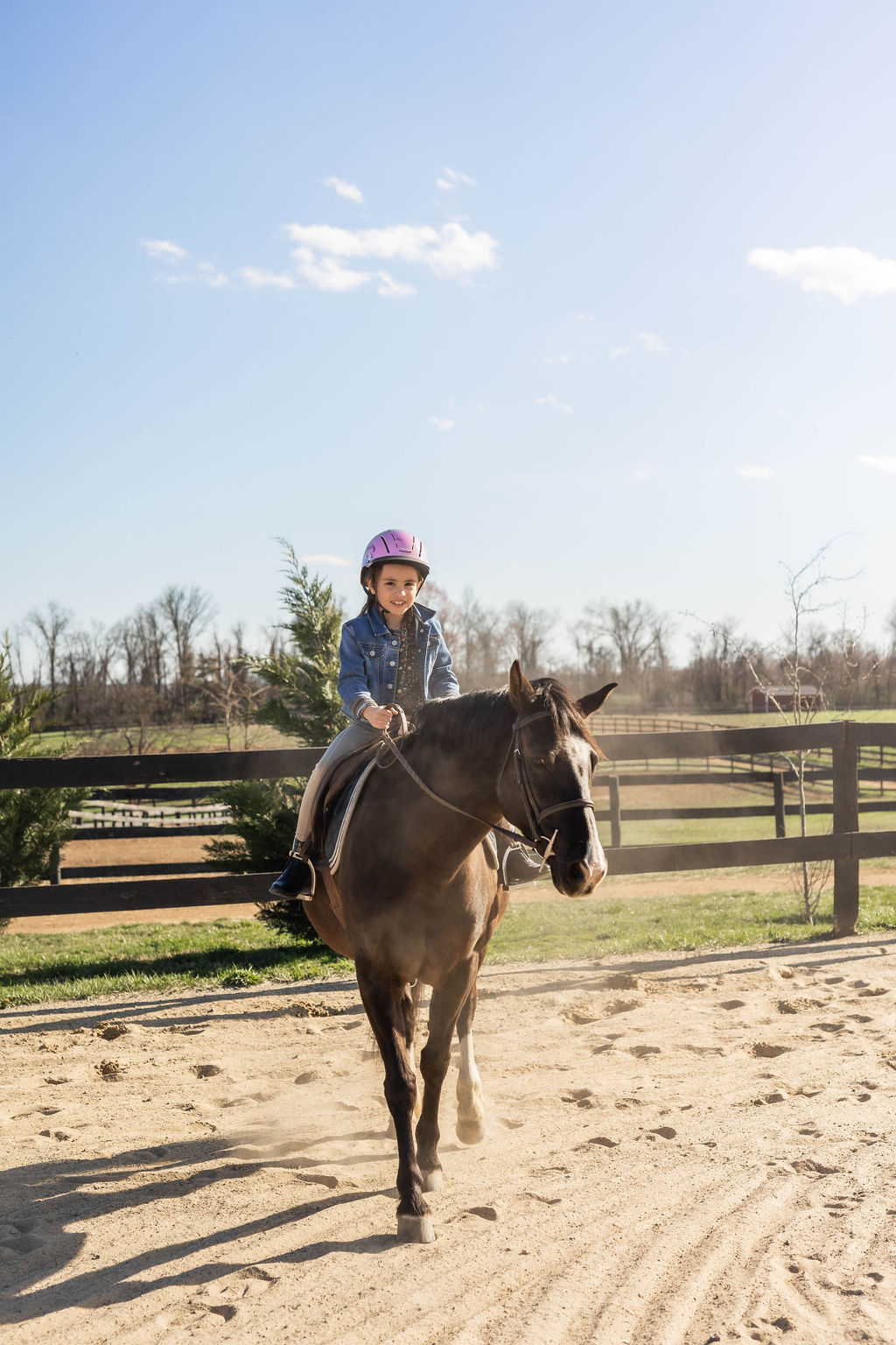 Young rider trotting confidently toward the camera in the arena
